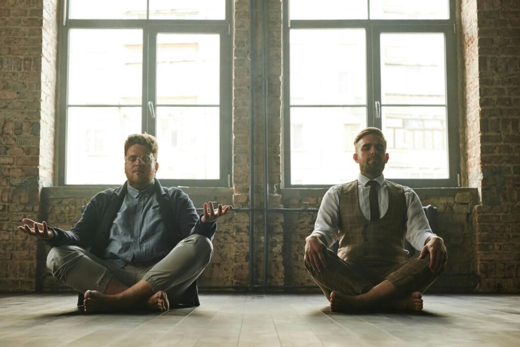 Two corporate professionals meditating in an office space, promoting relaxation as part of corporate wellness solutions for stress relief and productivity.