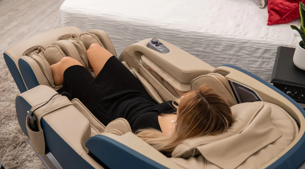 A woman relaxing in a luxurious electric massage chair with adjustable reclining and leg rest features, placed in a cozy living space.